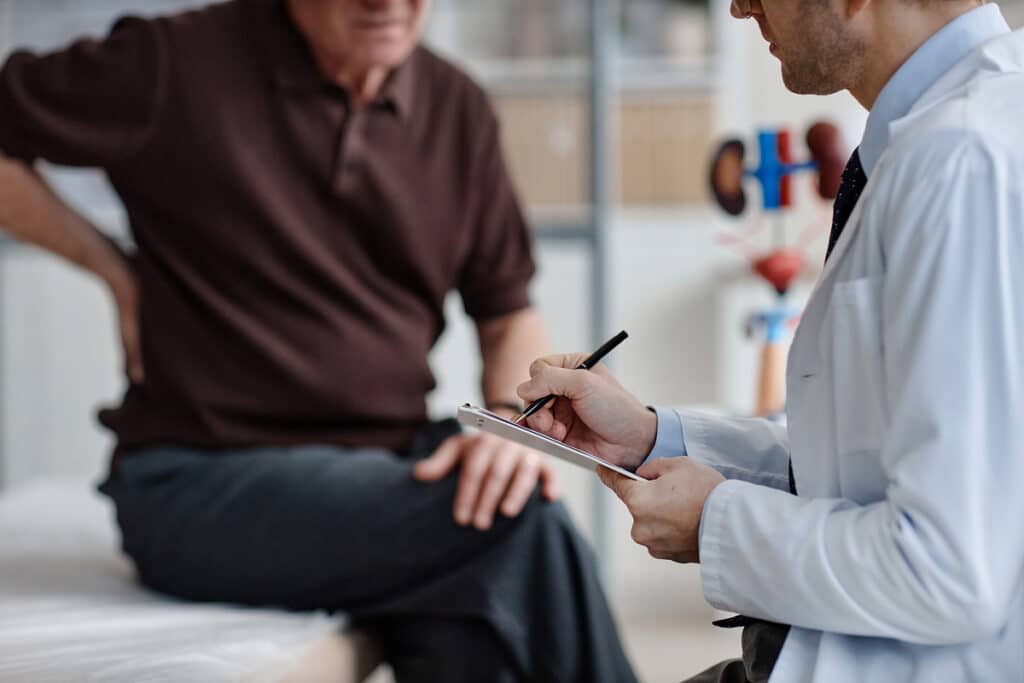 Physician consulting with patient in clinical setting, discussing diagnosis and treatment plan using clipboard notes